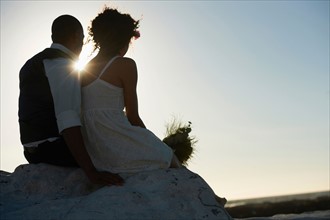 Newlywed couple looking at setting sun