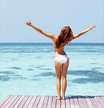 Young woman in bikini standing on jetty