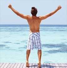 Man standing on swimming pool jetty