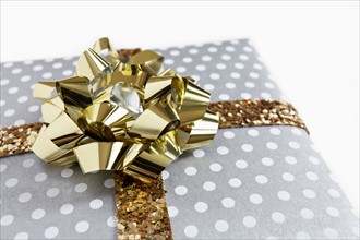 Close-up of gift with golden ribbon