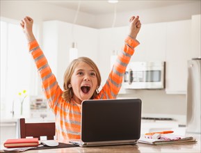 Excited girl (6-7) with laptop