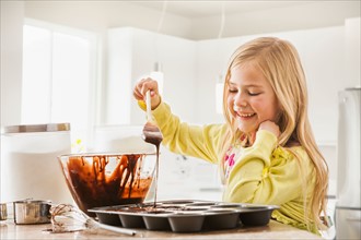 Girl (6-7) baking cupcakes