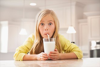 Blonde girl (6-7) drinking milk