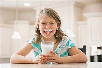 Girl (6-7) drinking milk