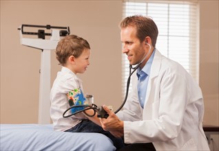 Pediatrician checking blood pressure of boy (2-3)