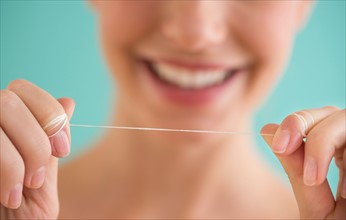 Close-up of woman holding dental floss.