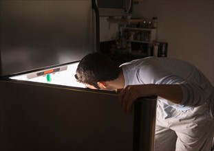 Man opening fridge at night.