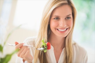 Woman eating and smiling.