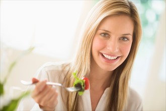 Portrait of woman eating and smiling.