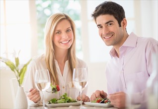 Portrait of couple eating dinner in restaurant.