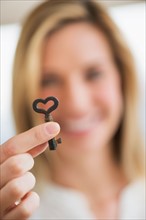 Woman holding heart-shaped key.