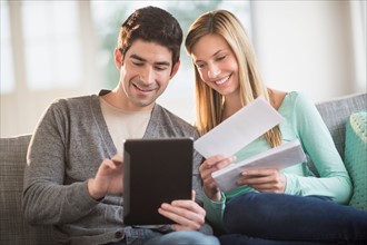 Couple using tablet pc to pay bills online.
