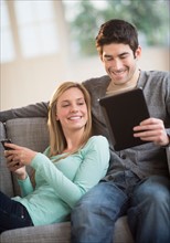 Couple using tablet pc and smartphone.