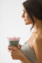 Woman holding tray with scented flower.
