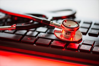 Close up of computer keyboard and stethoscope, studio shot.