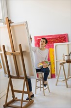 Female artist painting in her studio.