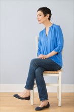 Portrait of mature woman sitting on chair.