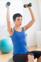 Mature woman exercising in gym.