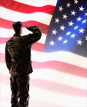 Army soldier saluting in front of American flag.