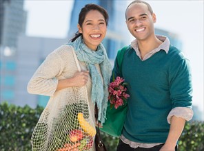 Portrait of happy couple with grocery shopping bags.