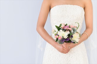 Bride in veil holding bouquet.
