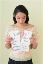 Young woman with torn list of expenses.