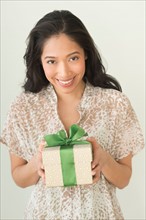 Young woman holding wrapped gift.