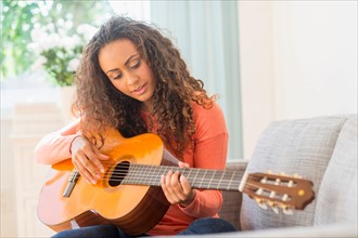 Young woman playing guitar.