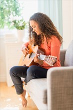 Young woman playing guitar.