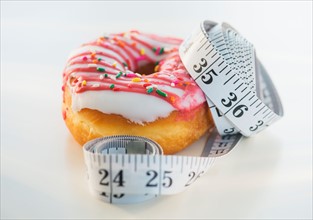 Studio Shot of tape measure wrapped around jelly doughnut