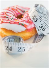 Studio Shot of tape measure wrapped around jelly doughnut
