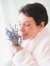 Portrait of mature woman smelling flowers