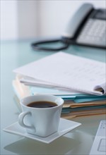 Close-up of coffee, paper material and telephone