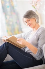 Portrait of woman reading on sofa