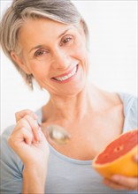 Portrait of woman eating grapefruit