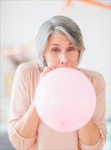 Portrait of woman blowing balloon