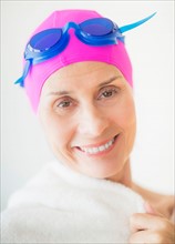 Portrait of smiling woman in swimming cap and goggles