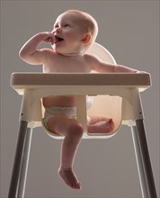 Studio shot of baby boy (18-23 months) sitting in baby seat