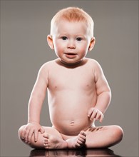 Studio shot of naked baby boy (18-23 months) sitting