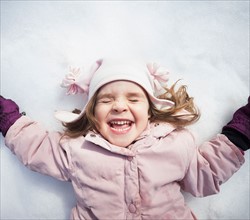 Portrait of Girl (2-3) lying down on snow