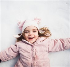 Directly above portrait of girl (2-3) lying on snow