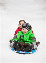 Portrait of two sledding children (2-3, 4-5)