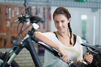 Woman with bicycle in workshop