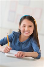 Portrait of schoolgirl (8-9) writing in notebook.