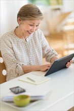 Senior woman using tablet pc at home.