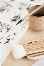 Calligraphy paintbrushes, ink and Japanese script.