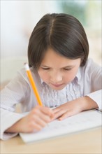 Girl (8-9) doing homework.