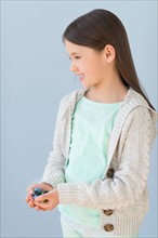 Girl (8-9) holding marbles.