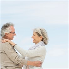 Senior couple embracing outdoors.