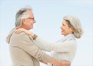 Senior couple embracing outdoors.